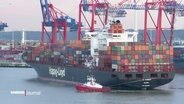 Ein beladenes Containerschiff der Reederei Hapag-Lloyd wird im Hamburger Hafen von einem Lotsenboot gezogen. © Screenshot 