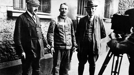 Der hannoversche Massenmörder Fritz Haarmann (Mitte) wird fotografiert. © picture-alliance / dpa 