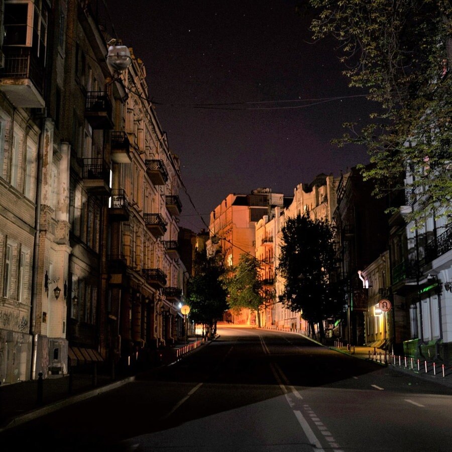 Eine Straße in einem Wohngebiet mit ausgeschalteter Straßenbeleuchtung während einer nächtlichen Ausgangssperre ist leer. © picture alliance/dpa/AP | Foto:  Jae C. Hong