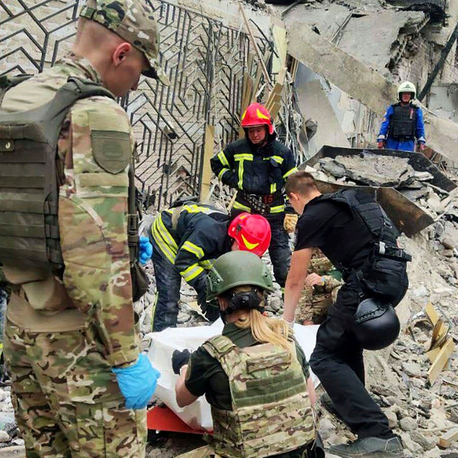 Auf diesem von der Nationalen Polizei der Ukraine zur Verfügung gestellten Foto arbeiten Rettungskräfte in der Nähe des durch einen Angriff zerstörten Restaurants RIA Pizza. © National Police of Ukraine/AP/dpa 
