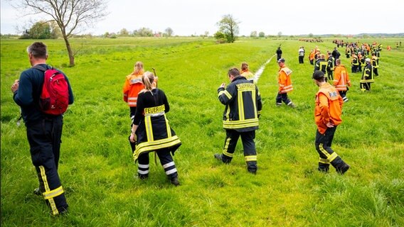 Feuerwehrleute suchen mit einer Menschenkette auf einem Feld nach dem vermissten Jungen Arian aus Bremervörde. © dpa Bildfunk Foto: Daniel Bockwoldt