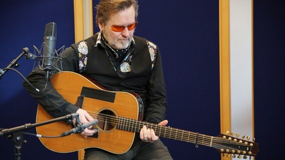 Der Musiker Stoppok sitzt mit seiner Gitarre im Studio von NDR 90,3.  Foto: Kathrin Otto
